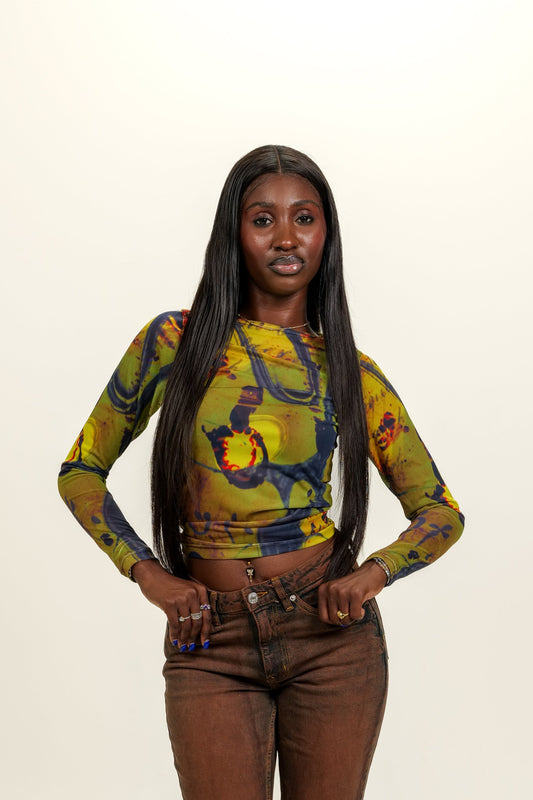 Woman wearing a patterned top and brown pants on a white background